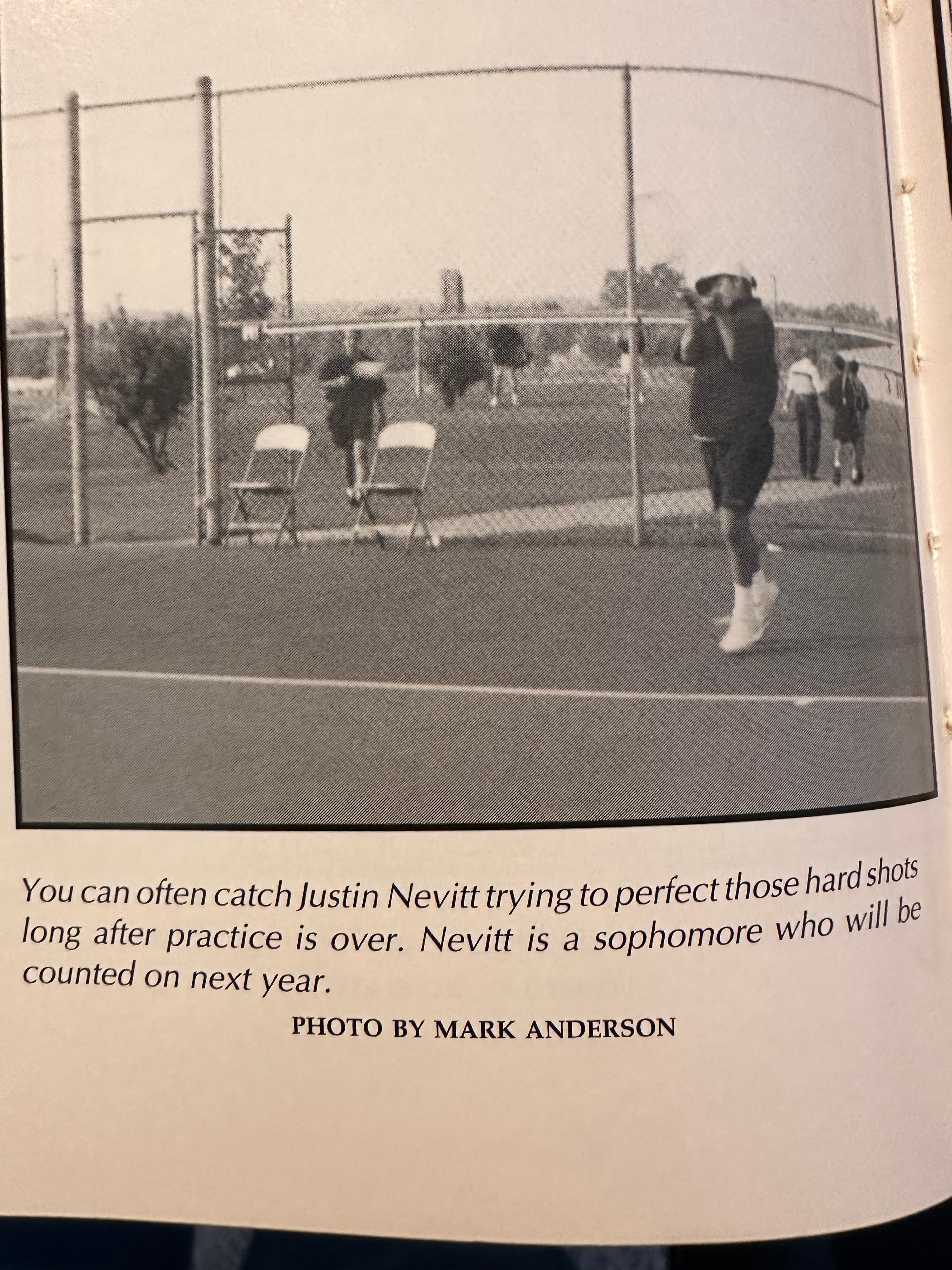 Young Justin Nevitt practicing tennis after practice — yearbook photo