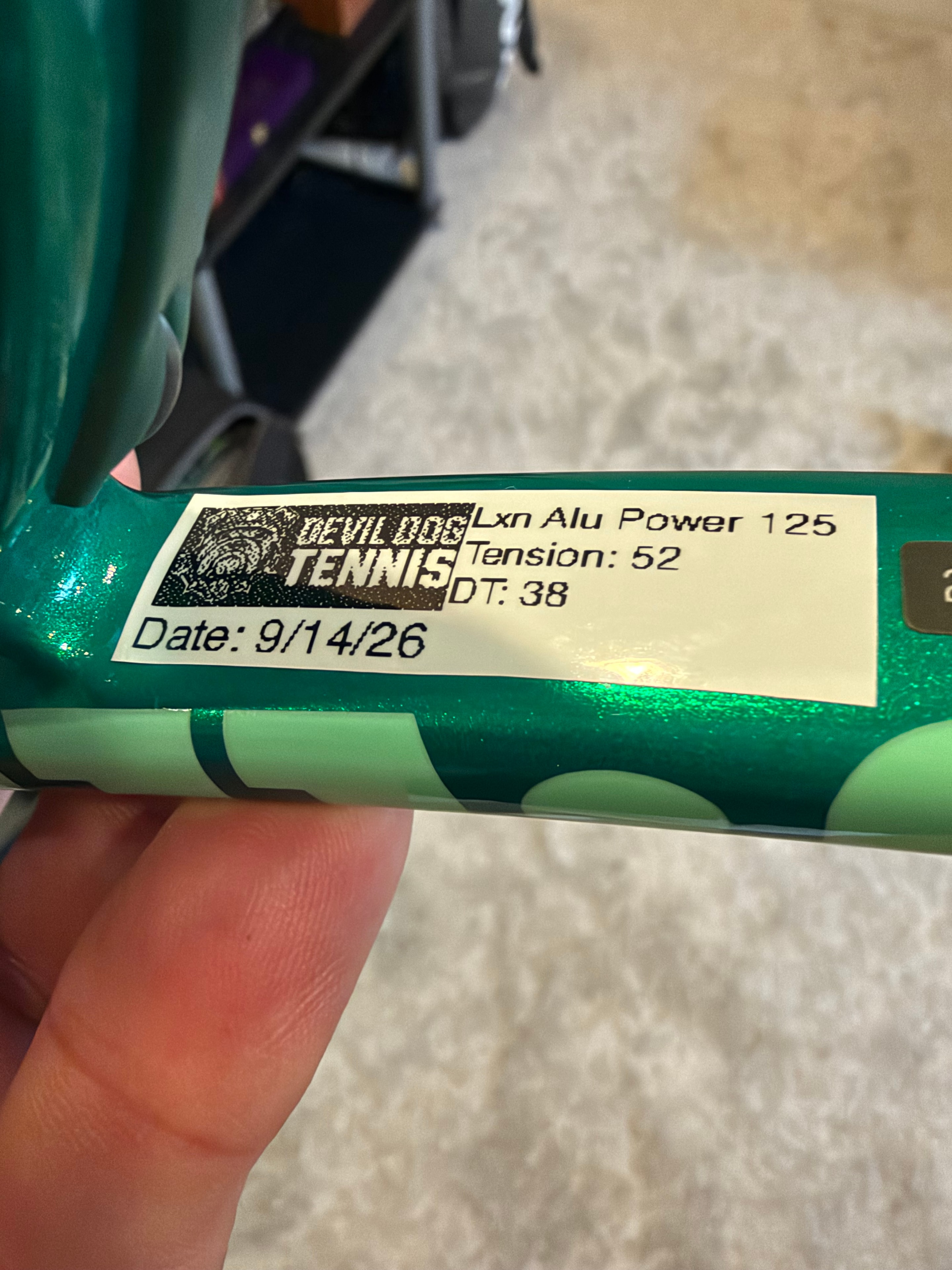 Devil Dog Tennis stringing label on a racket handle — Luxilon Alu Power 125 at 52 lbs