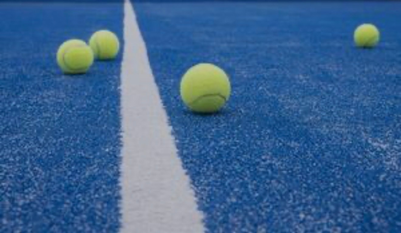 Tennis balls scattered on a blue hard court